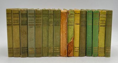 several old books are lined up in a row on a white surface