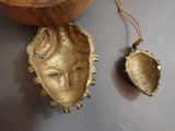 a shell with a face on it next to a wooden bowl