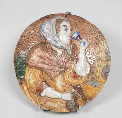 une photo d'une assiette décorative représentant une femme tenant un oiseau