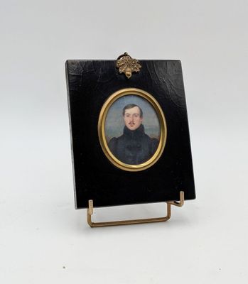 miniature portrait of a man in a black coat with a gold frame