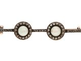 a close up of a pair of cuff bracelets with white stones