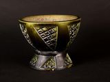 a gold and silver bowl sitting on a black surface