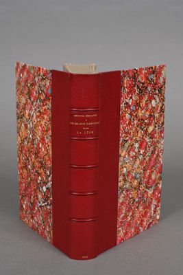 an open book with a red cover sitting on top of a table
