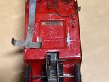 un petit camion rouge en plastique posé sur une table
