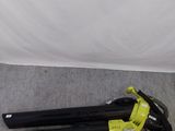 une photo d'un souffleur à fil posé par terre devant un mur blanc