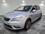 une voiture argentée garée dans une pièce au sol en damier