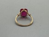 a close up of a gold ring with a pink stone