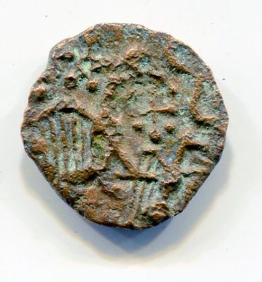 an old coin with a design on it sitting on a white surface