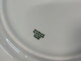 a close up of a white plate with a green design on it