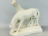 sculpture en porcelaine représentant un cheval et un poulain sur un socle blanc