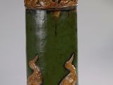 une image représentant un vase vert et marron orné de deux lapins