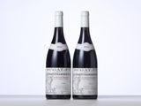 two bottles of red wine sitting next to each other on a table