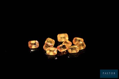 a group of yellow sapphires on a black surface