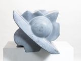 a sculpture of a flower on a pedestal on a white surface