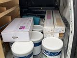 boxes and buckets of paint sit in the back of a van
