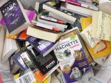 une pile de livres posée sur un lit