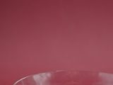a clear glass bowl on a red surface