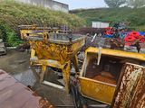 a yellow dump truck parked next to a pile of junk