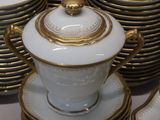 a lot of white and gold plates and cups and saucers