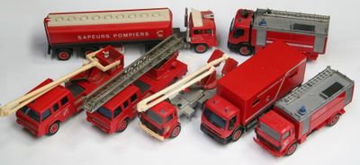 de nombreux camions de pompiers et camions miniatures posés sur une surface blanche
