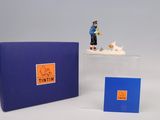 une petite figurine représentant un homme et un chien, dans une boîte