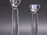 une paire de bougeoirs en verre transparent posés sur une table