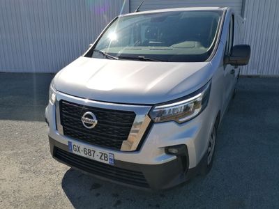 une camionnette argentée garée devant un immeuble blanc