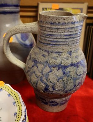 un vase bleu et blanc posé sur une table à côté d'une assiette