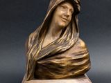 a bronze statue of a woman with a veil on her head