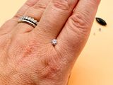 a woman ' s hand with a diamond ring on it
