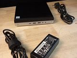 un ordinateur portable et un chargeur posés sur une table en bois