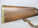 an old wooden rifle mounted on a white surface with a white background