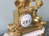 a gold clock sitting on top of a marble table