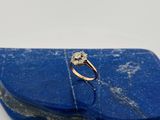 un gros plan d'une bague en diamant posée sur une pierre bleue