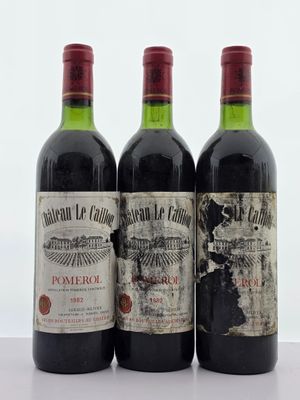 trois bouteilles de vin rouge posées sur une table blanche