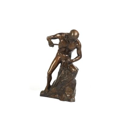 statue en bronze représentant un homme tenant un couteau, assis sur un rocher