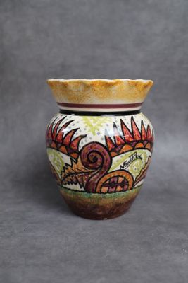 un petit vase orné d'un motif sur fond gris
