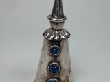 une image représentant une clochette en argent ornée de pierres bleues