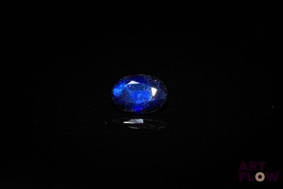 a close up of a blue sapphire stone on a black surface