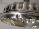 a close up of a silver plate with a light on it