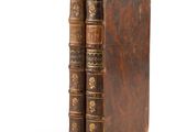 an old pair of books sitting next to each other on a white surface