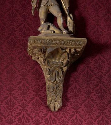 une statue représentant un homme tenant une épée, posée sur une étagère
