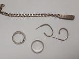 un bracelet en argent, une bague et une chaîne posés sur une table