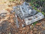 a pile of concrete blocks on the ground next to a fence