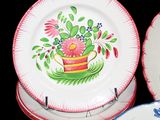 three plates with flowers painted on them sitting on a table