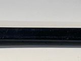 a black pen that is laying on a white surface