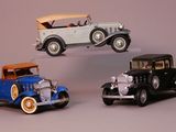 three toy cars sitting next to each other on a table