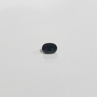 une petite pierre noire posée sur une surface blanche