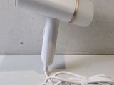 a white hair dryer sitting on a table next to a charger