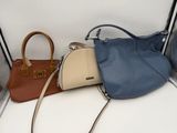 three purses sitting on the floor next to each other